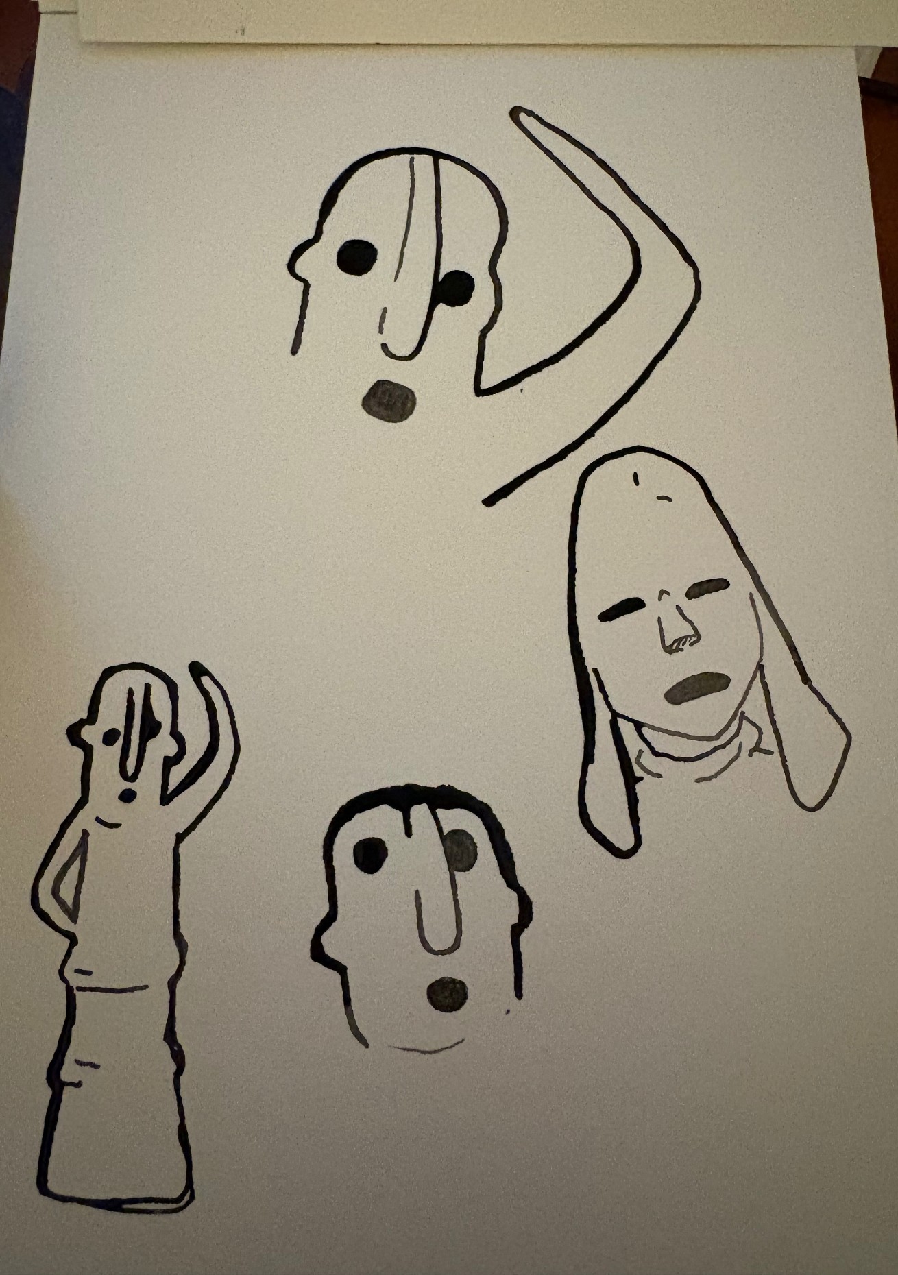 Sketchbook page of haniwa face and head studies in bold ink lines