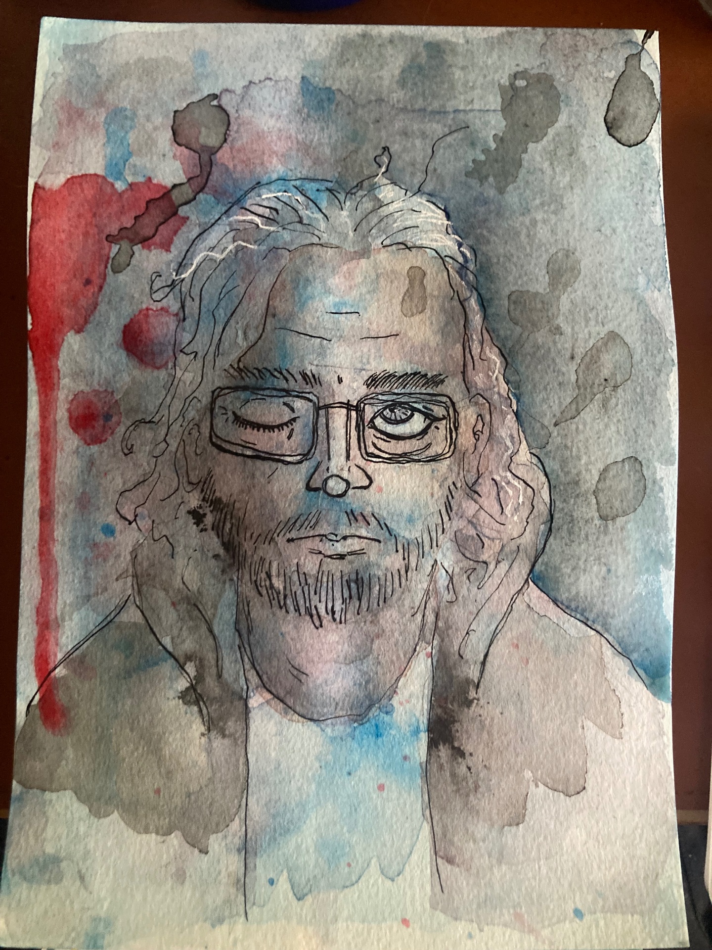 Watercolour and ink self-portrait of a bearded man with long hair and glasses, one eye winked